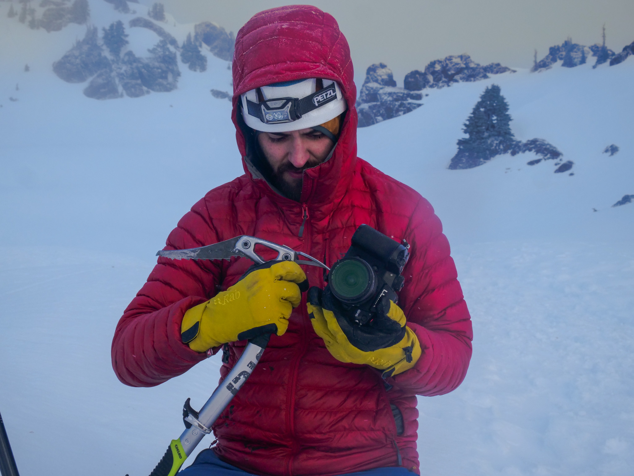 Cameraman with ice axe on snowy mountain