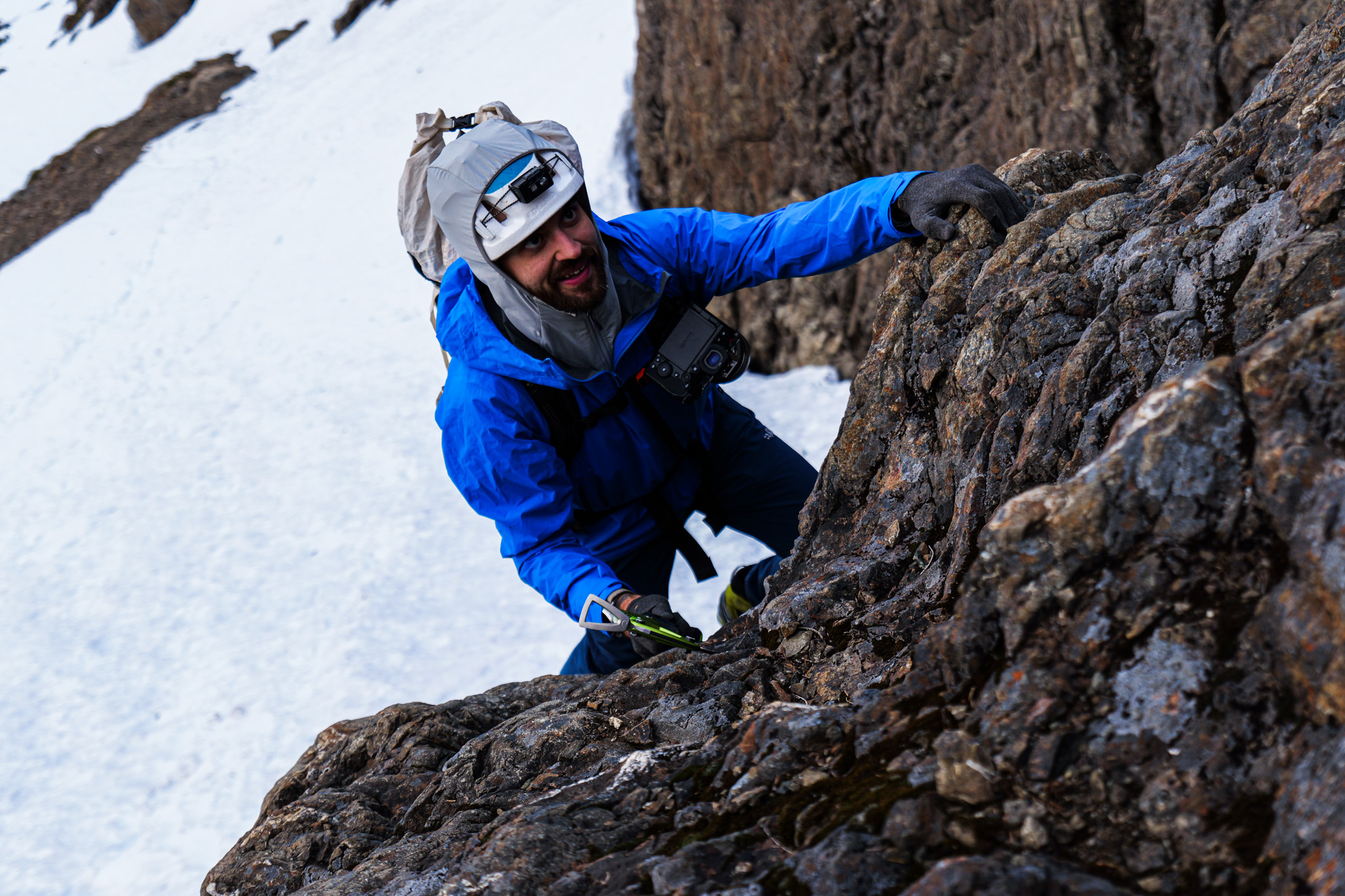 Climber on rock face with ice axe